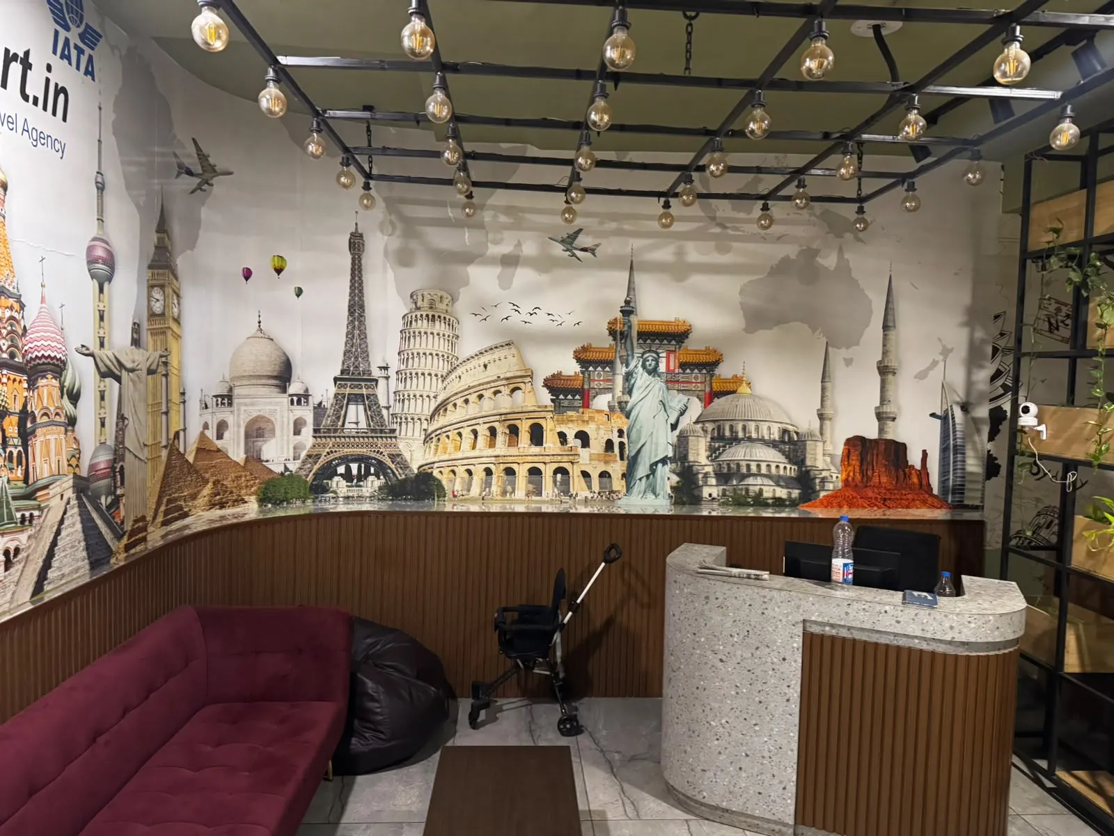 The waiting area, with a sofa, a front desk and a mural of world landmarks